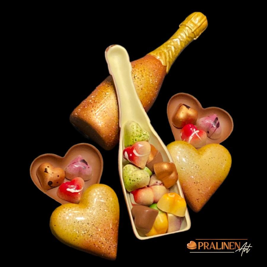 Sektflasche aus Schokolade mit Pralinen und Schokoladenherzen